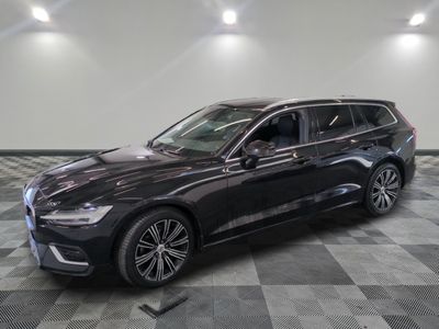 a black volvo wagon parked on a checkered floor in a showroom