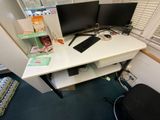 a computer desk with two monitors and a keyboard on it