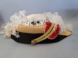 a black hat with gold trim and a red ribbon