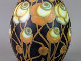 un vase noir orné de fleurs jaunes et bleues