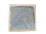 a square blue plate with a brown rim on a white surface