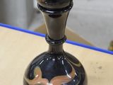 un vase noir posé sur une table en bois