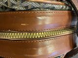the inside of a brown and white bag with a zipper