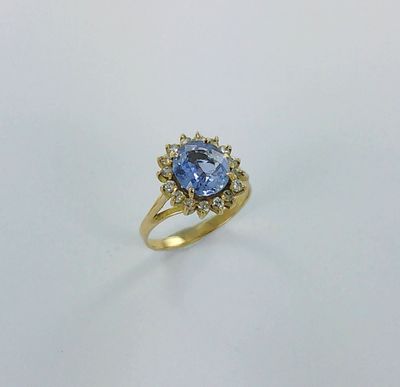 une bague en or sertie d'un saphir beige entouré de diamants blancs