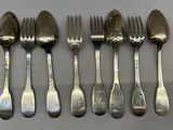 six fourchettes et cuillères sont alignées sur une table