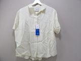 shirt hanging on a hanger on a wall with a tag on it
