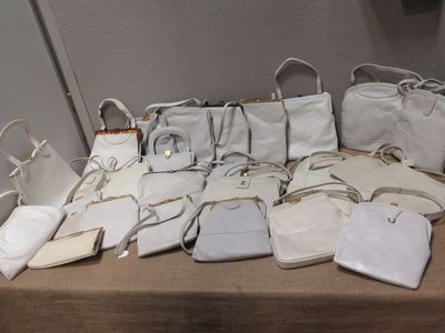 une table sur laquelle sont posés de nombreux sacs à main et sacs
