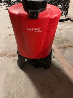 a red container with a black lid sitting on the floor