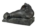 statue d'un chat endormi posée sur un socle en pierre, sur fond blanc