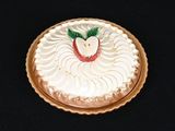 un gâteau recouvert de glaçage blanc et surmonté d'une pomme rouge