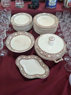 many plates and glasses on a table with a red table cloth
