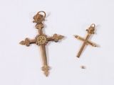 two gold crosses on a white surface next to each other