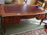 un bureau avec un plateau en cuir et une chaise dans une pièce