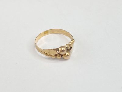 gros plan d'une bague en or sur une surface blanche