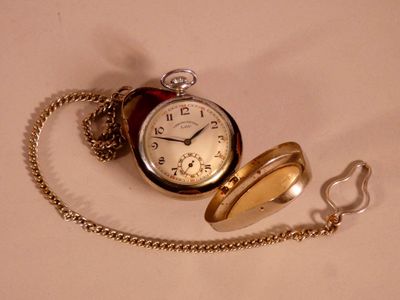 a pocket watch with a chain around it on a table