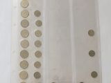 three rows of coins in a clear plastic bag on a white surface