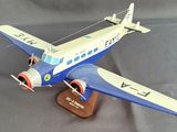 a small model of a blue and white plane on a wooden stand