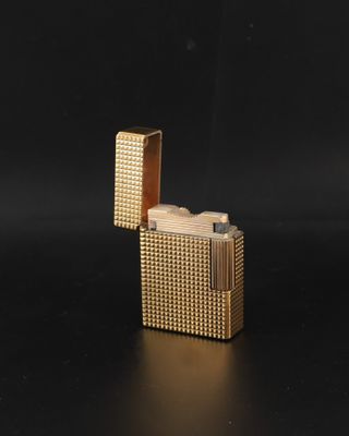 un briquet doré posé sur une surface noire