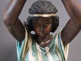 statue of a woman holding a banana over her head