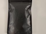 a black bag of food sitting on a white surface