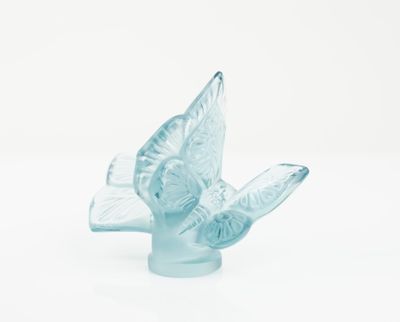 an image of a glass bird figurine sitting on top of a white surface