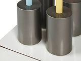 four different colored toothbrushes in a holder on a counter