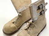 une paire de bottes beiges à boucles sur fond blanc