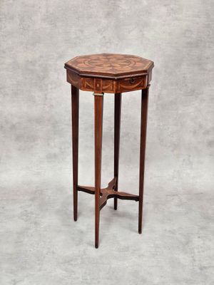 une petite table ronde avec un plateau en bois sur fond gris