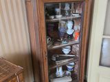 une armoire avec une porte vitrée, placée dans un coin de la pièce