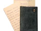 un vieux portefeuille noir posé sur une feuille de papier, à côté d'une autre feuille de papier