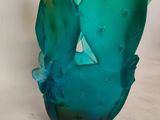 a glass vase with a green and blue design on it