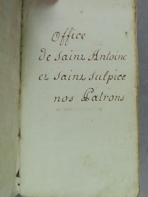 un livre ouvert avec une écriture dessus, posé sur une table