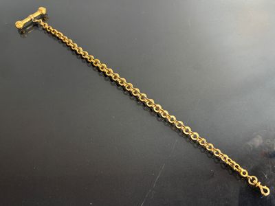 a close up of a gold chain bracelet on a black surface