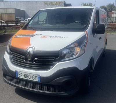 a white van with an orange and white stripe parked in a parking lot