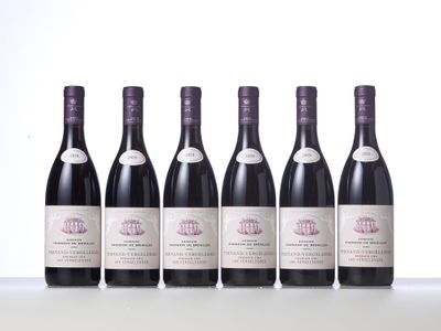 six bottles of wine are lined up on a table