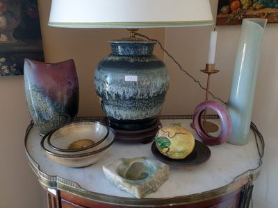 une table sur laquelle se trouvent une lampe, des vases et d'autres objets