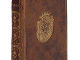 un vieux livre avec un emblème en or sur la couverture
