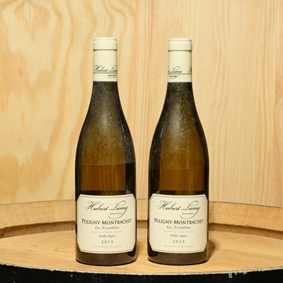 deux bouteilles de vin posées sur un tonneau en bois