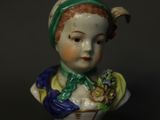 une petite figurine représentant une femme coiffée d'un chapeau