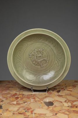 une vieille assiette verte posée sur une table en marbre