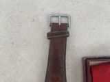 an image of a watch with a medal and a red ribbon