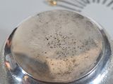 a silver object on a table with screws and screws