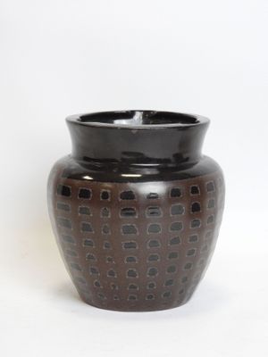 a brown vase with a black lid on a white background