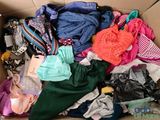 a cardboard box filled with lots of clothes and clothes