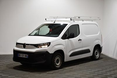 la camionnette blanche est garée dans une pièce au sol en damier