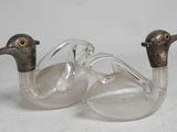 pair of clear glass ducks sitting next to each other on a white surface