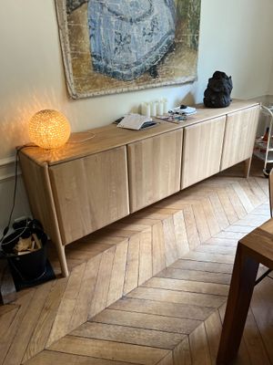 a picture of a living room with wood floors and a large painting on the wall