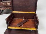 a small wooden box with a knife inside of it