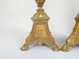 pair of antique brass candlesticks with ornate designs on bases