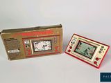 a small red and white electronic game in a box